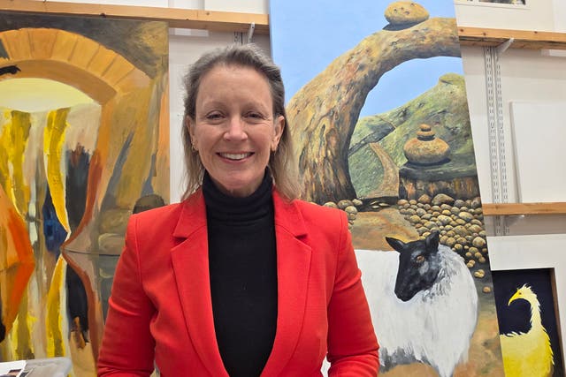 <p>The artist and poet Frieda Hughes stands in front of some of her paintings</p>