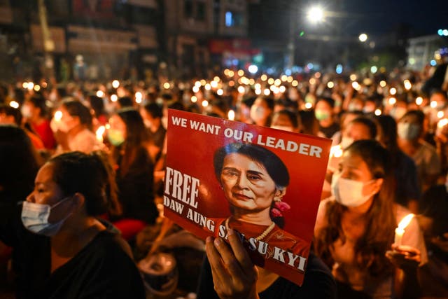 <p>A protester holds a poster with an image of detained civilian leader Aung San Suu Kyi during demonstrations against the military coup in Yangon on 13 March 2021</p>
